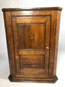 Shelved oak corner cupboard with inlaid design, approx height 98cm