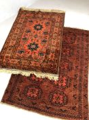 Two small Eastern red ground rugs, the largest approx 155cm x 117cm