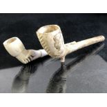 Two vintage clay pipes, one with depiction of Queen Victoria and a coat or arms, the other in the