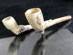 Two vintage clay pipes, one with depiction of Queen Victoria and a coat or arms, the other in the