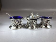 Three silver hallmarked salts with pierced decoration depicting hunting dogs and blue glass liners