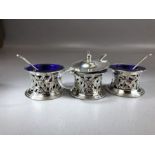 Three silver hallmarked salts with pierced decoration depicting hunting dogs and blue glass liners