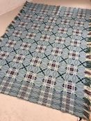 Vintage textiles: Welsh woven bedspread / blanket with tasselled ends, in shades of pale blue, green