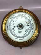 Brass cased circular aneroid barometer, the porcelain dial inscribed `Gamage, London`, mounted on an