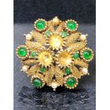 Gold coloured Brooch set with an outer ring of six larger green stones punctuated with seed pearls