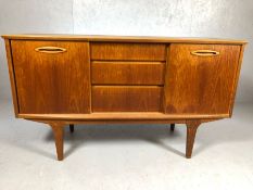 Mid Century small sized sideboard on legs with three drawers to central and cupboards to each