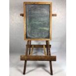 Large wooden vintage easel with fabric straps and supporting a wooden framed blackboard, total