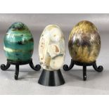 Collection of three decorative ceramic eggs on stands, the largest approx 7.5cm (inclu. stand)