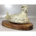 Clay figure in siren form, approx 25cm in length, on wooden plinth