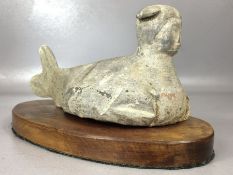 Clay figure in siren form, approx 25cm in length, on wooden plinth