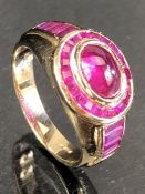 9ct Gold ring set with a cabochon rubywith a halo of Gemstones and square cut gemstones to