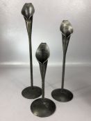 Set of three graduating metal candlesticks in the form of Lillies