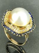 Large single Pearl on yellow gold mount surrounded by a halo of diamonds and then individually set
