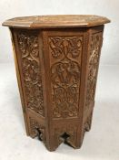 Small octagonal carved wooden tea table with hinged folding base and floral design, approx 57cm in