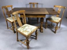 Extendable dining table of carved light oak with heavily carved legs and two integrated leaves,