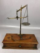 Pair of De Grave Short & Co brass scales on stained rectangular wooden base, with pendulum-style