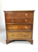 Cabinet with two drawers and pair of faux drawers opening to cupboard with brass circular handles,