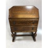 Oak bureau with fall front revealing leather writing desk, two drawers, on carved legs