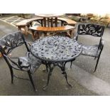 Black metal garden table and two chairs with ornate floral design, table approx 80cm in diameter