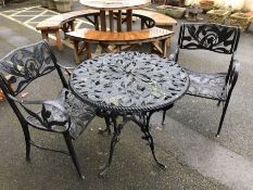 Black metal garden table and two chairs with ornate floral design, table approx 80cm in diameter