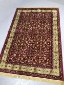 Red ground Kashmir rug with all-over floral pattern and gold border approx. 240cm x 160cm