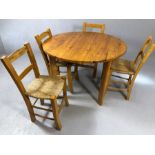 Circular pine table and four rush seated chairs