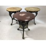 Set of three pub tables with cast iron bases and wooden tops, each approx 60cm in diameter x 70cm in