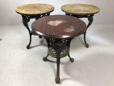 Set of three pub tables with cast iron bases and wooden tops, each approx 60cm in diameter x 70cm in