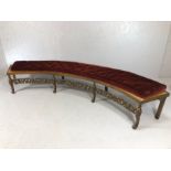 Large oak and rush seated curved window seat, heavily carved, on eight legs, with carved heart