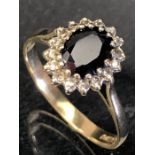 9ct Gold ring set with a large central red stone and surrounded by diamonds size 'Q'