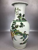 Large Chinese vase with white ground and green decoration, depicting Chinese figures in a landscape,