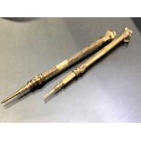 Two Victorian propelling pencils, gold cased, chased with leafy scroll decoration and the ends inset