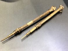 Two Victorian propelling pencils, gold cased, chased with leafy scroll decoration and the ends inset