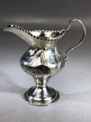 Silver Hallmarked for London Victorian cream jug with repousse decoration on circular foot approx