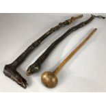 Collection of three carved wooden tribal clubs, two with woven leather straps, the longest approx