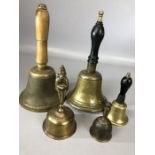 Collection of five brass hand bells, two possibly Indian, three with turned wooden handles, of