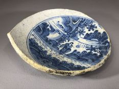 Sectional piece of a ceramic bowl, possibly Chinese with blue and white design of a figure in a