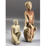 Two carved wooden figures, one on bended knee, the larger with remnants of painted detailing and