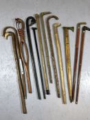 Good collection of walking sticks, of varying designs, some with brass tops and tips, the longest