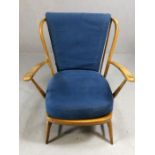 Mid Century blond stick back armchair, possibly Ercol, with blue cushions