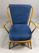 Mid Century blond stick back armchair, possibly Ercol, with blue cushions