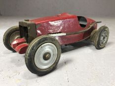 Vintage red metal model of racing car, in the style of a Bugatti, with untested petrol engine,
