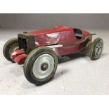 Vintage red metal model of racing car, in the style of a Bugatti, with untested petrol engine,