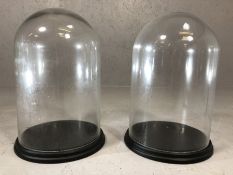 Pair of vintage glass display domes, each approx 40cm in height, on wooden bases