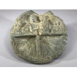 Circular stone carving, the top half depicting four figures holding objects in their hands, the