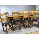 Modern oak extending dining table with eight matching oak dining chairs with upholstered seats
