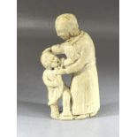 Carved bone folk art-type figure of a woman and child, approx 10cm in height