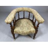 Edwardian elbow chair with turned supports and upholstered seat and arms, on castors