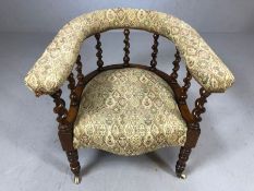 Edwardian elbow chair with turned supports and upholstered seat and arms, on castors