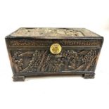 Small heavily carved Chinese camphor wood chest with brass fittings on square carved feet, approx